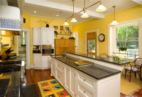 steel appliances black countertop white cabinets and yellow walls kitchen|white kitchen cabinets with black countertops.